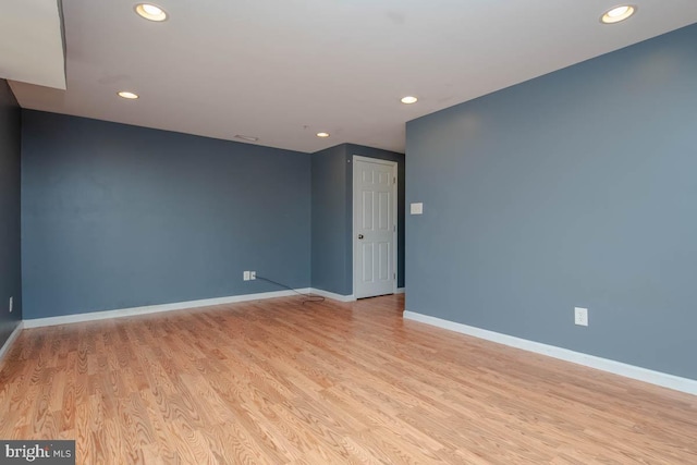 empty room featuring light wood-type flooring, baseboards, and recessed lighting