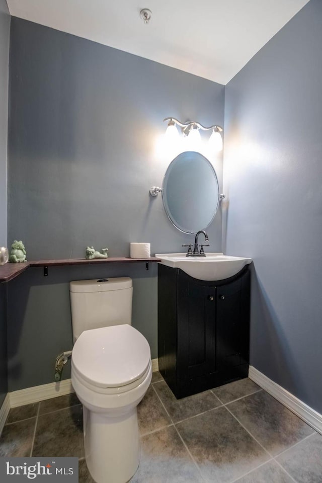 bathroom with baseboards, vanity, toilet, and tile patterned floors