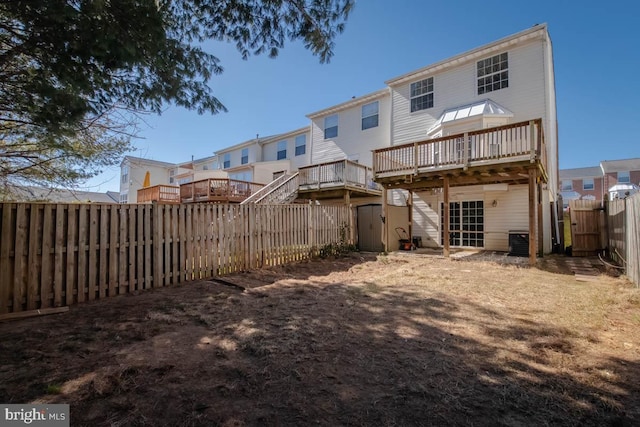 back of house featuring central AC unit, a fenced backyard, and a wooden deck