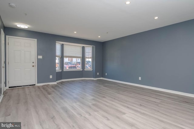 interior space with baseboards, wood finished floors, and recessed lighting