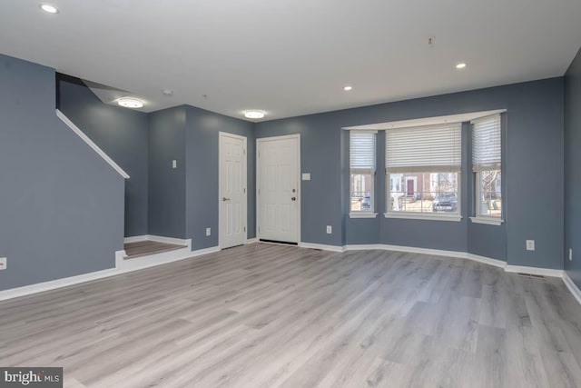 unfurnished living room with recessed lighting, baseboards, and wood finished floors