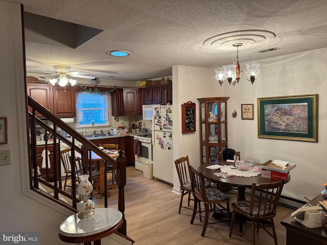 dining area featuring light wood finished floors, visible vents, stairs, a textured ceiling, and ceiling fan with notable chandelier