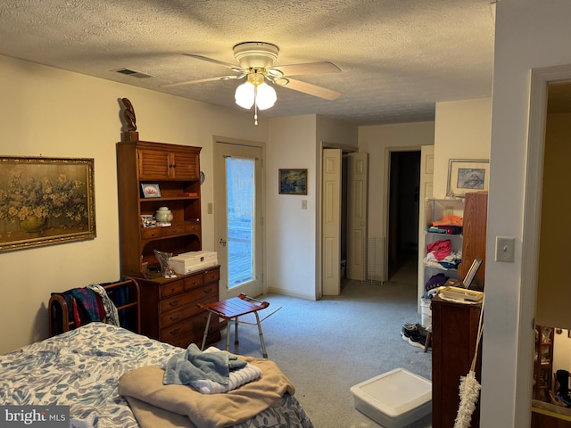 bedroom with light carpet, access to exterior, visible vents, and a textured ceiling