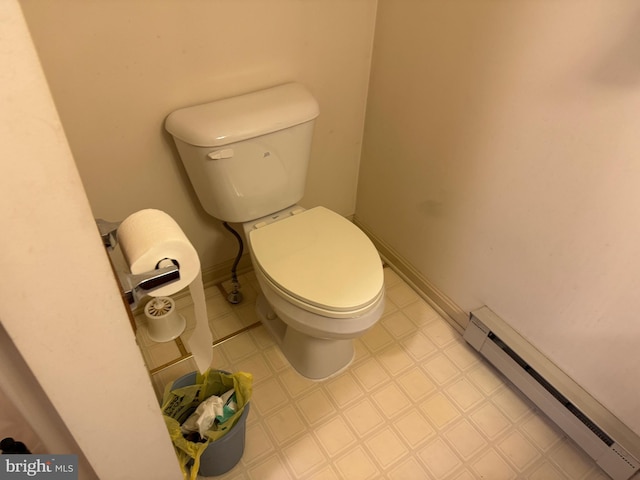 bathroom with toilet, baseboards, a baseboard heating unit, and tile patterned floors