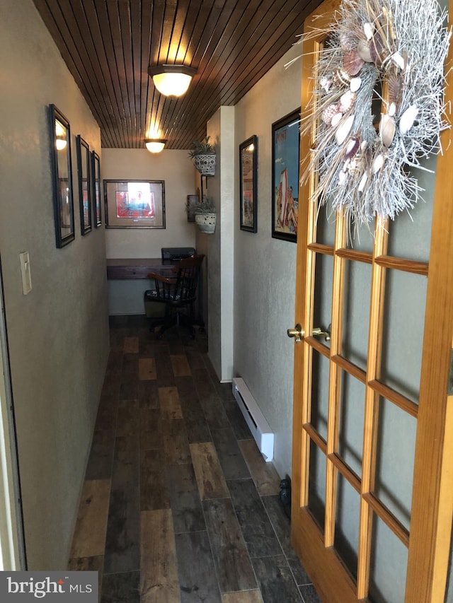 corridor featuring a baseboard heating unit, wood finished floors, and wood ceiling