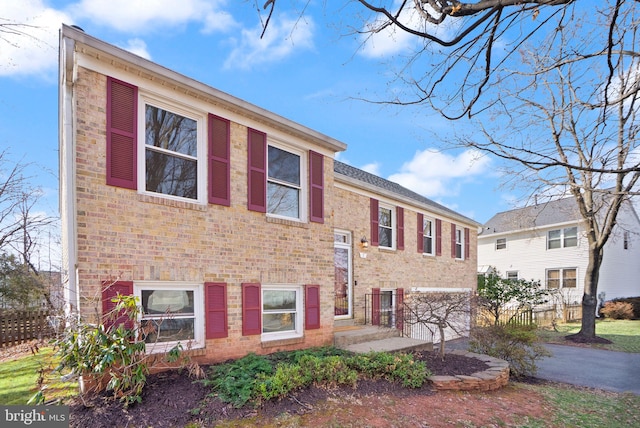 view of front of home featuring fence and brick siding