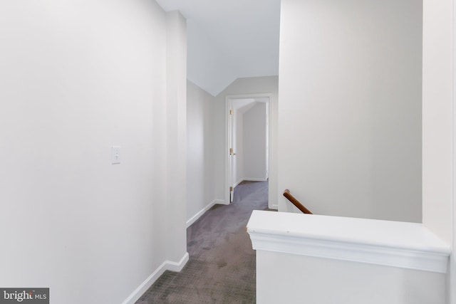 hallway with vaulted ceiling, carpet floors, an upstairs landing, and baseboards