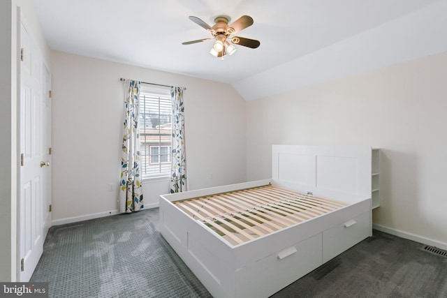 unfurnished bedroom featuring visible vents, baseboards, ceiling fan, carpet, and vaulted ceiling