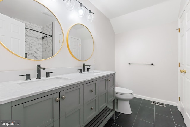 bathroom with double vanity, tile patterned flooring, baseboards, and a sink