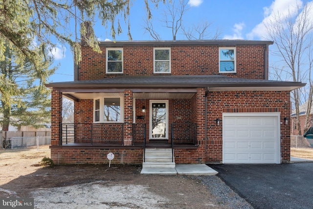 traditional home featuring a garage, driveway, brick siding, and a porch