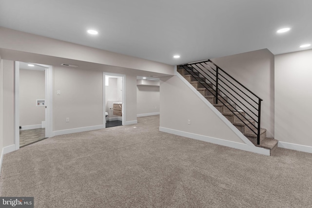 finished below grade area featuring carpet floors, recessed lighting, visible vents, stairway, and baseboards