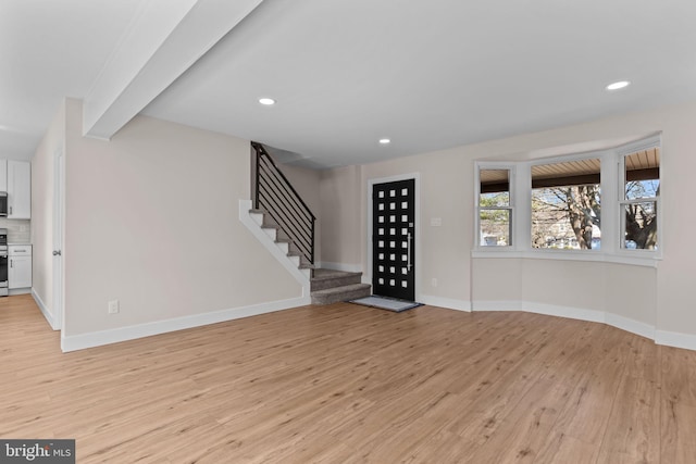 interior space featuring light wood-type flooring, recessed lighting, baseboards, and stairs