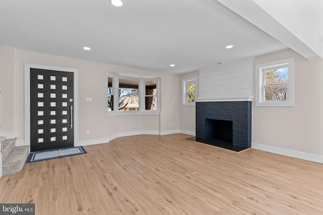 foyer featuring a healthy amount of sunlight, light wood finished floors, and baseboards