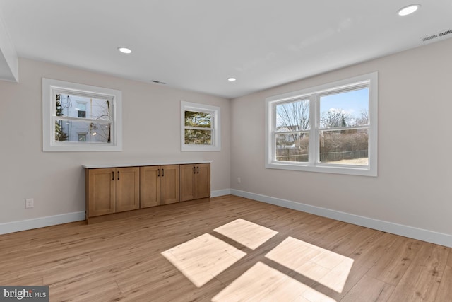 interior space featuring light wood-style flooring, visible vents, and baseboards