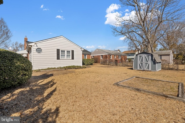 view of yard with a shed, fence, and an outdoor structure