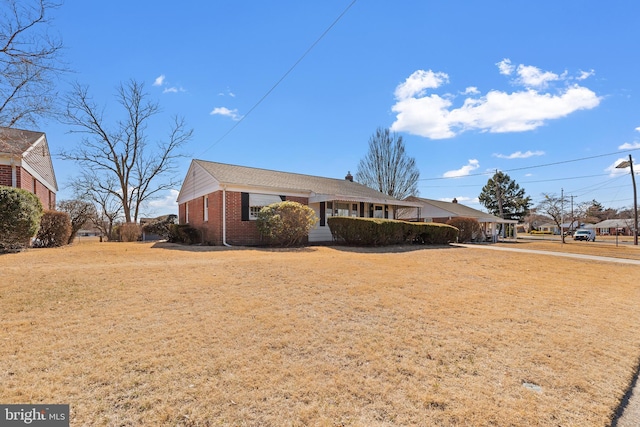 view of side of property featuring brick siding, a lawn, and a chimney