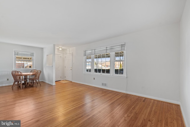 spare room featuring light wood finished floors, baseboards, and visible vents