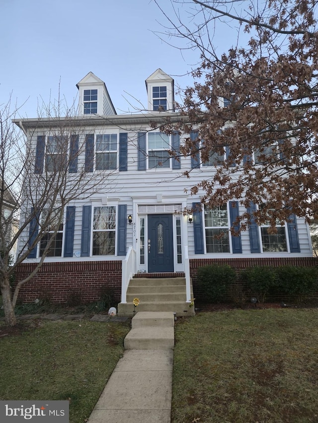 view of front of property featuring a front yard and brick siding