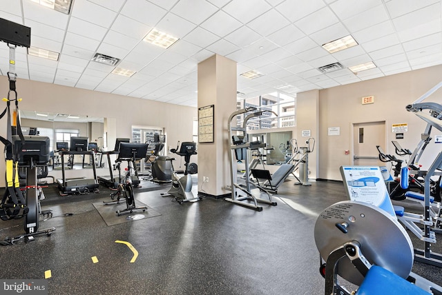 workout area with visible vents, a drop ceiling, and a wealth of natural light