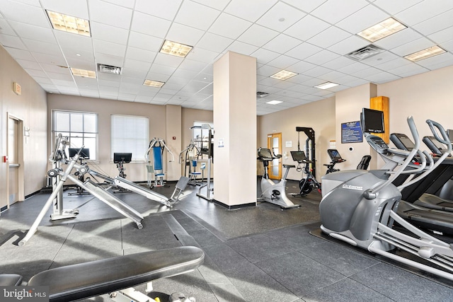 workout area with a paneled ceiling, visible vents, and baseboards