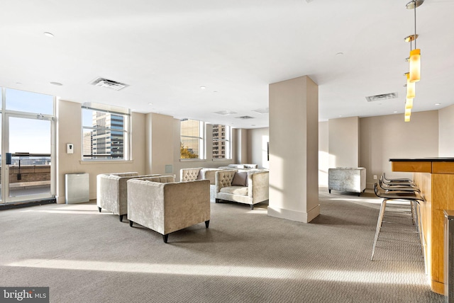 living room featuring carpet, a healthy amount of sunlight, and visible vents