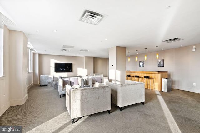 carpeted living area with a bar, baseboards, and visible vents