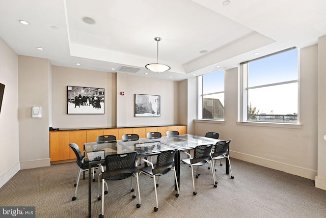 carpeted dining room with a tray ceiling, recessed lighting, and baseboards