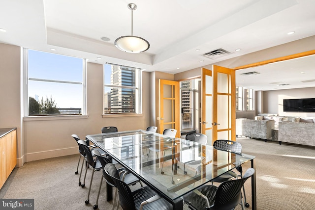 dining area featuring baseboards, visible vents, and light colored carpet