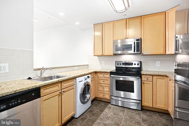 kitchen featuring washer / dryer, appliances with stainless steel finishes, a sink, and light brown cabinetry