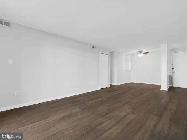 unfurnished living room featuring dark wood-style floors, visible vents, and a ceiling fan