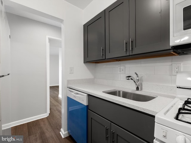 kitchen with white appliances, dark wood-type flooring, a sink, and decorative backsplash