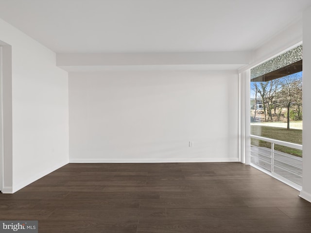 unfurnished room featuring dark wood finished floors and baseboards