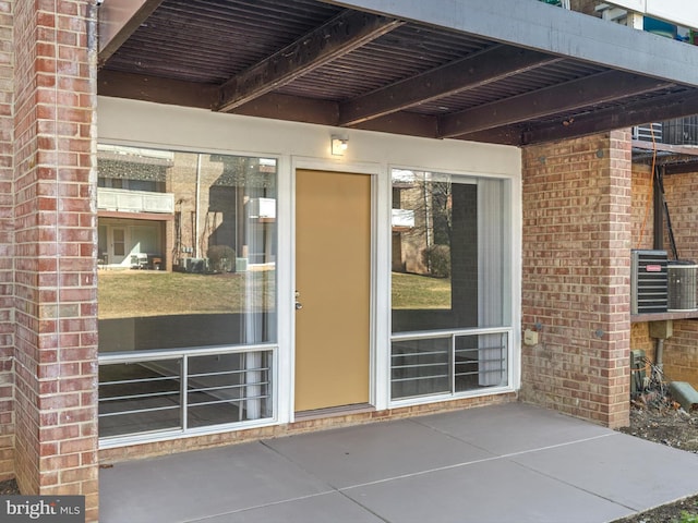 entrance to property with cooling unit and brick siding