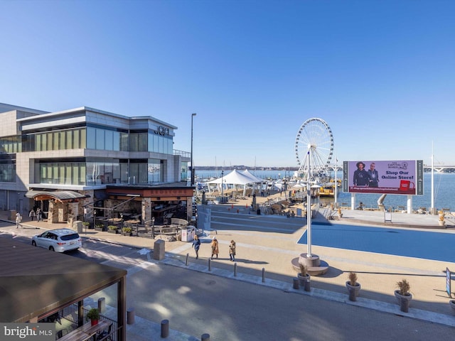 exterior space featuring curbs, a water view, and sidewalks