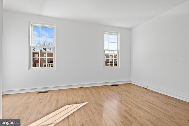 spare room featuring visible vents and wood finished floors