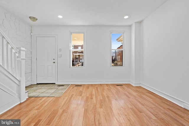 entrance foyer featuring baseboards, stairway, wood finished floors, and recessed lighting