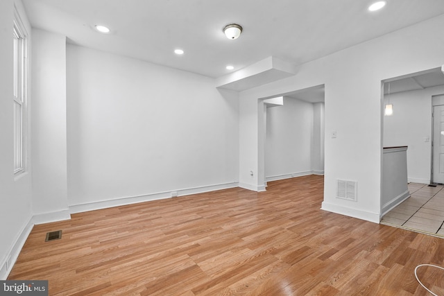 below grade area featuring light wood-style flooring, visible vents, and recessed lighting