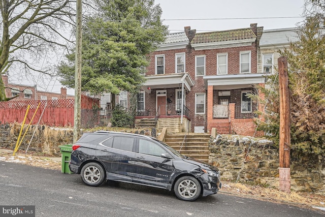 view of property featuring fence and brick siding