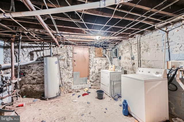 unfinished basement featuring washing machine and dryer, electric panel, and gas water heater