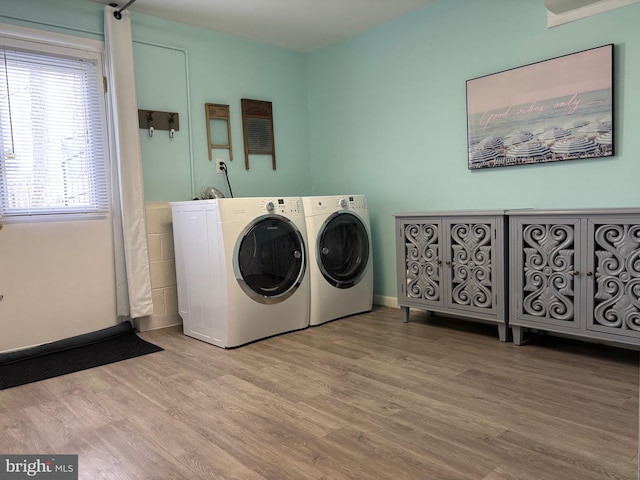 laundry area with laundry area, independent washer and dryer, wood finished floors, and baseboards