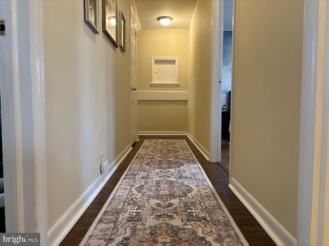 hall featuring dark wood finished floors and baseboards