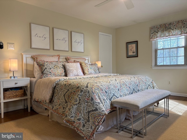 bedroom with a ceiling fan, baseboards, and wood finished floors