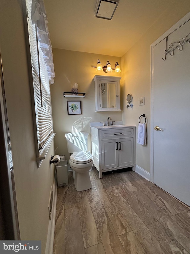 bathroom with vanity, toilet, and baseboards