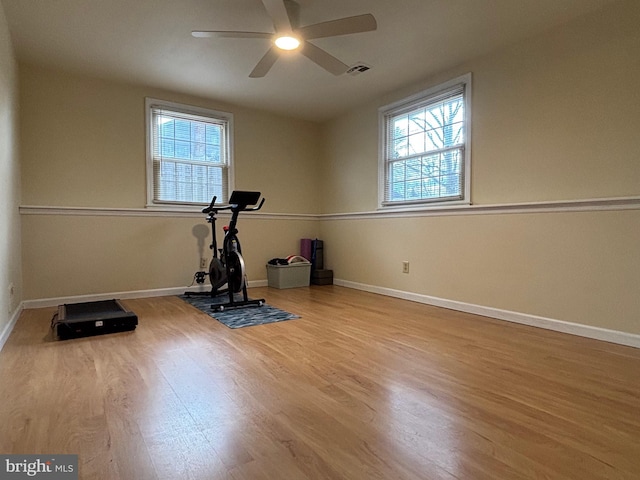 exercise room with a healthy amount of sunlight, visible vents, baseboards, and wood finished floors