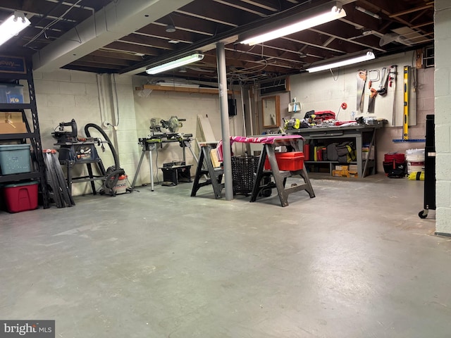 unfinished basement with concrete block wall and a workshop area