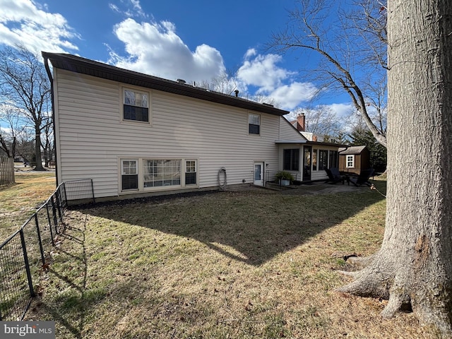 rear view of property with a yard and fence