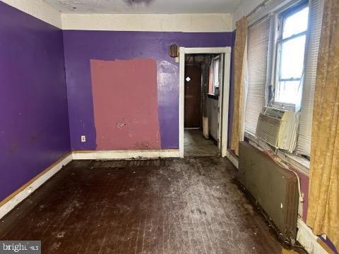 unfurnished room with cooling unit and baseboards