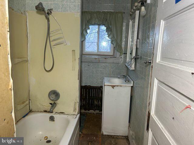 bathroom with vanity, tile walls, and bathing tub / shower combination