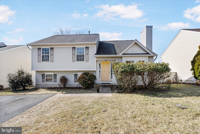 split level home with a front lawn and a chimney