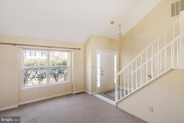 carpeted foyer entrance with lofted ceiling, baseboards, stairs, and visible vents